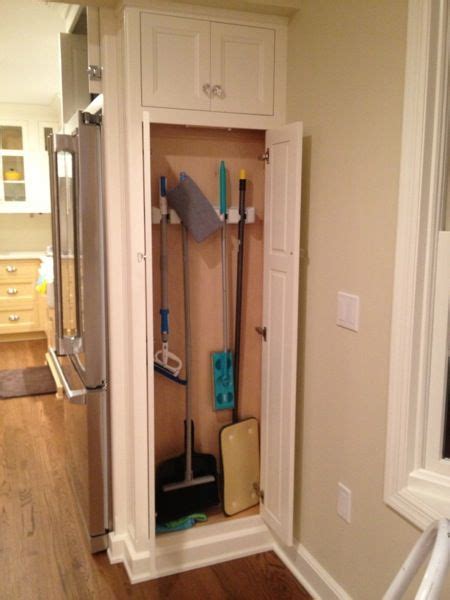 broom closet next to refrigerator.